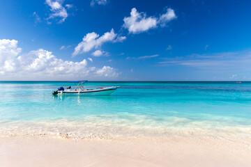 Coastal Caribbean landscape with fishing boat anchored near empty sandy beach