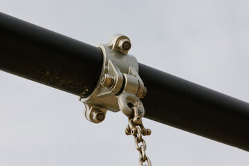 Close-up of the metal mount and chain of an outdoor children's swing.