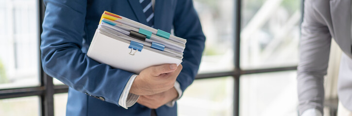 Businessman Preparing reports papers with graphs, charts on Stacks of documents files for finance in office. Piles unfinished achieves with paper clip near computer. Concept of Business Annual Report.