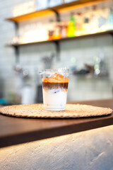 An ice milk coffee in plastic cup and served on counter bar. Drink and beverage object photo.