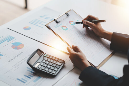 Accountant working on desk using calculator to calculate financial report in office business accounting finance concept
