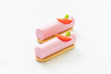 Vegan dessert. Two Strawberry cream cakes. Dessert bar on cookies. Decorated with fresh strawberry slice. White background