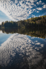 reflected clouds  at the small forest lake water