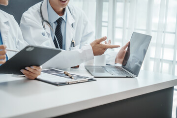 Asian medical doctors specialist in white lab coats working together, discussing at meeting about blood test results, anemia, infection in the bloodstream, diabetes