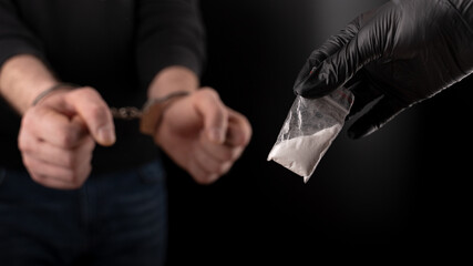 Polizeikurier für Drogenhaftungen. festgenommener Händler hält eine kleine Tüte Kokain in der Hand.