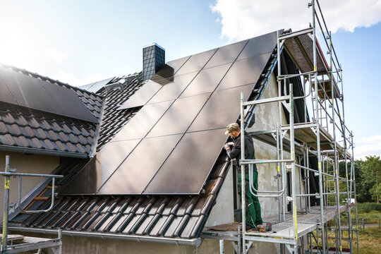 Technician working on a solar panel at a construction site of a single family house