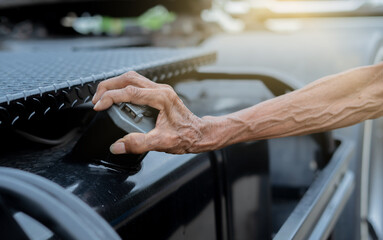 Close up elderly man hand open the cap of fuel tank of a  truck .