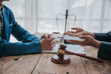 Judge gavel with Justice lawyers having team meeting at law firm in background. Concepts of law.