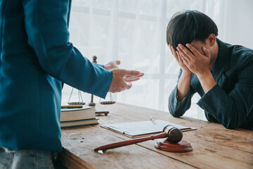 Stressed young Asian businessman consulting lawyer and having lawyer support in lawyer office