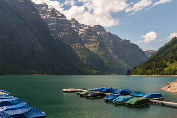 Jetty with boats on the shore of Lake Kloentalersee, Kloental, Glarner Alps, Canton Glarus, Switzerland