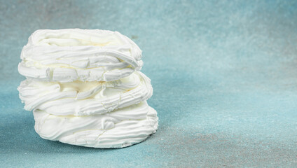 Multilayered meringue dessert on a blue background, Long banner format