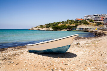 Fototapeta na wymiar A wooden boat on the quiet beach with no one, by the sea