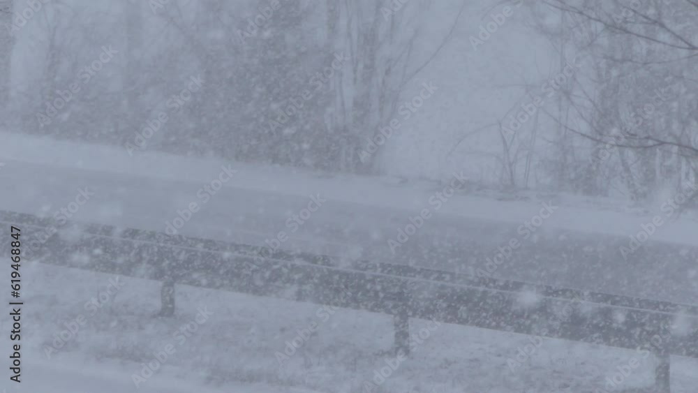 Poster snowstorm and car passing on two-way road with poor visibility on road. winter scene with falling sn