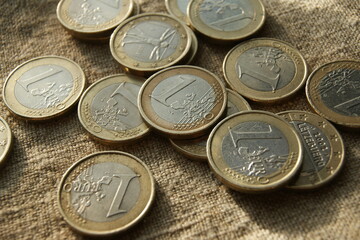 European money. Poured 1 Euro coins on natural linen fabric.