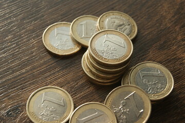 European coins. 1 euro coins on a dark wooden table