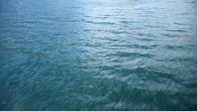 low flight over a clear blue water surface, background Blue water waves surface, beautiful background with copy space. Fresh drinking water,