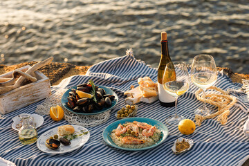 Table full of seafood and vegetable dishes with sea horizone in the background