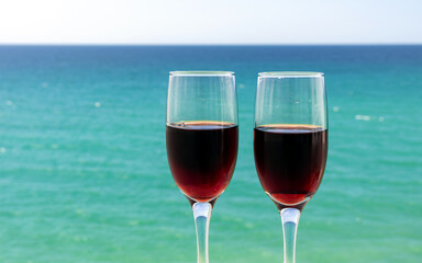 two glasses of wine on the background of the sea surface