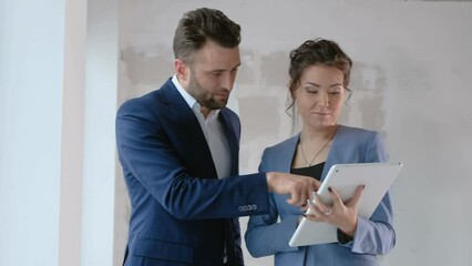 Two business persons talking about investment in real estate indoors. Construction concept: female agent speak with consultant closeup