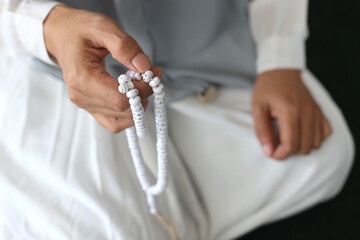 Close up of hands holding prayer beads in a mosque