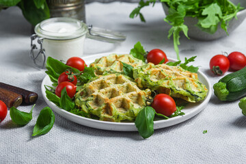 Zucchini waffles with arugula and cherry tomatoes in a plate