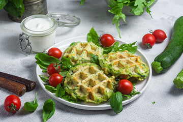 Zucchini waffles with arugula and cherry tomatoes in a plate