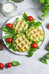 Zucchini waffles with arugula and cherry tomatoes in a plate