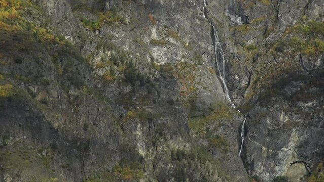 View over the steep mountain walls of  Sognefjord,  Aurlandsfjord Flam, Norway. Impressive mountain landscape of fjords and a waterfall