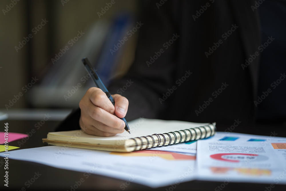 Aufkleber close-up of a businesswoman using a pen to write a wooden desktop notebook and a memo list.