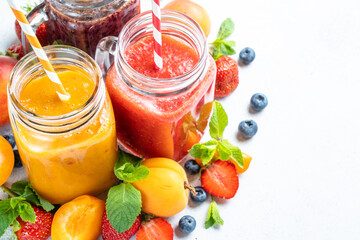 Smoothie with fresh fruits and berries at white background.