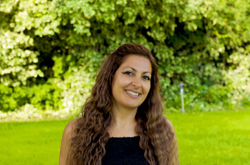 Naklejka premium portrait of a beautiful woman in the green garden with flowers