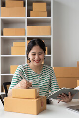 Obraz na płótnie Canvas Successful SME entrepreneur. Asian woman working on receipt box and check online orders. business sme concept