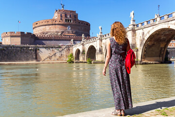 Tourist looks at Castel Sant’Angelo, adult girl walks in Rome, Italy, Europe