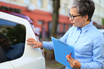 Mature female expert describes car damage.
