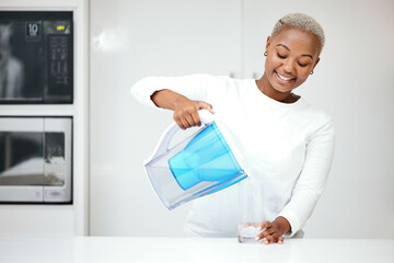 Water, filter and black woman with jug in kitchen to refresh with glass, liquid and cold hydration. Happy, thirsty and female person pouring pure aqua beverage from pitcher for clean drinking at home - obrazy, fototapety, plakaty