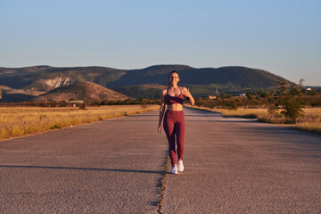 Healthy young couple jogging in the city streets in the early morning with a beautiful sunrise in the background