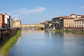 Fototapeta na wymiar Arno River and Ponte Vecchio in the Background on a Beautiful Sunny Spring Day in Florence, Italy