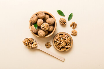 Walnut kernel halves, in a wooden bowl. Close-up, from above on colored background. Healthy eating Walnut concept. Super foods with copy space