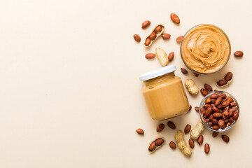 Bowl of peanut butter and peanuts on table background. top view with copy space. Creamy peanut...