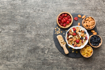 Cooking a wholesome breakfast. Granola with Various dried fruits and nuts in a bowl. The concept of a healthy dessert. Flat lay, top view with copy space
