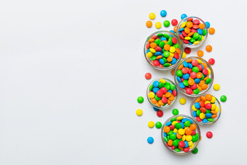 different colored round candy in bowl and jars. Top view of large variety sweets and candies with copy space