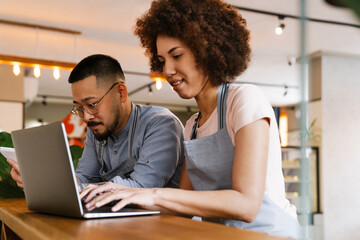 Two business owners using laptop while working in cafe