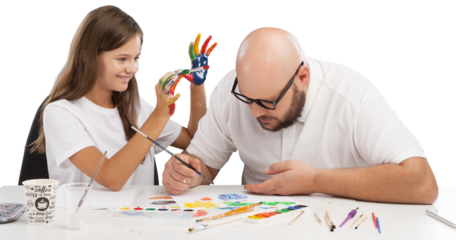 Painting concept. Schoolgirl painting with father during therapy at home with his tutor with learning and having fun together.