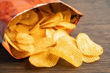 Potato chips, delicious BBQ seasoning spicy for crips, thin slice deep fried snack fast food in open bag.