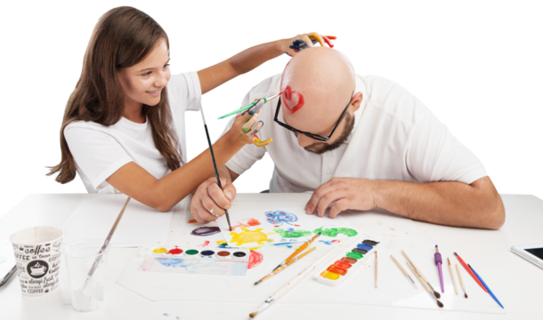 Painting concept. Schoolgirl painting with father during therapy at home with his tutor with learning and having fun together.