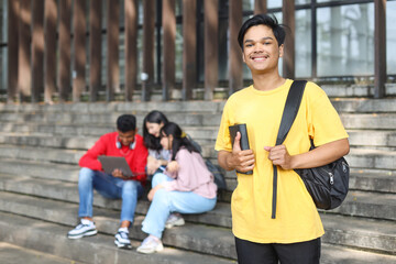 Portrait of young Asian student smiling happy wearing a backpack at the university.
