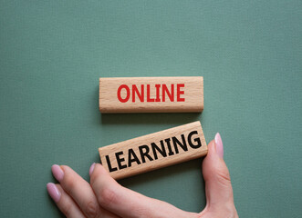 Online learning symbol. Wooden blocks with words Online learning. Beautiful grey green background. Businessman hand. Business and Online learning concept. Copy space.