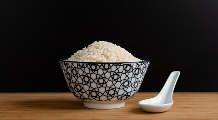 Bol de riz cru de style asiatique sur une planche en bois