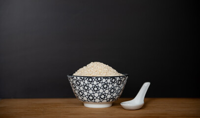 Bol de riz cru de style asiatique sur une planche en bois