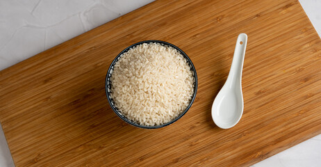 Bol de riz cru de style asiatique sur une planche en bois